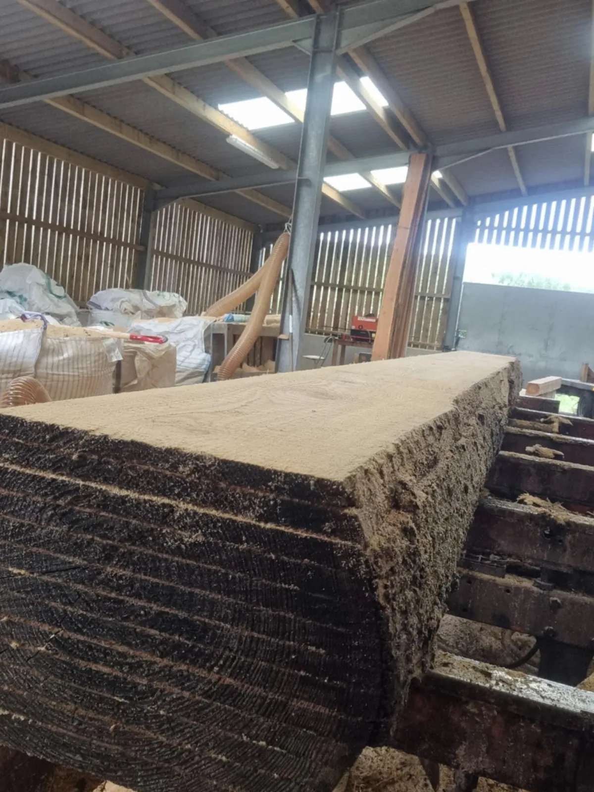 H.R.A Sawmill Services' mobile mill cutting a log in the yard shed